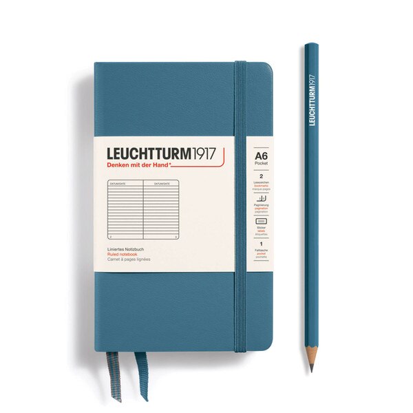 A stone blue hardcover notebook with an elastic to keep it closed.
